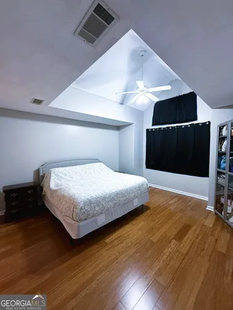 a bedroom with a bed and wooden floor