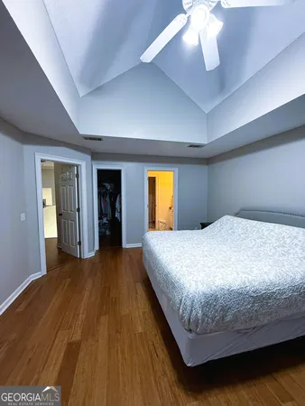 a spacious bedroom with a bed and a flat screen tv