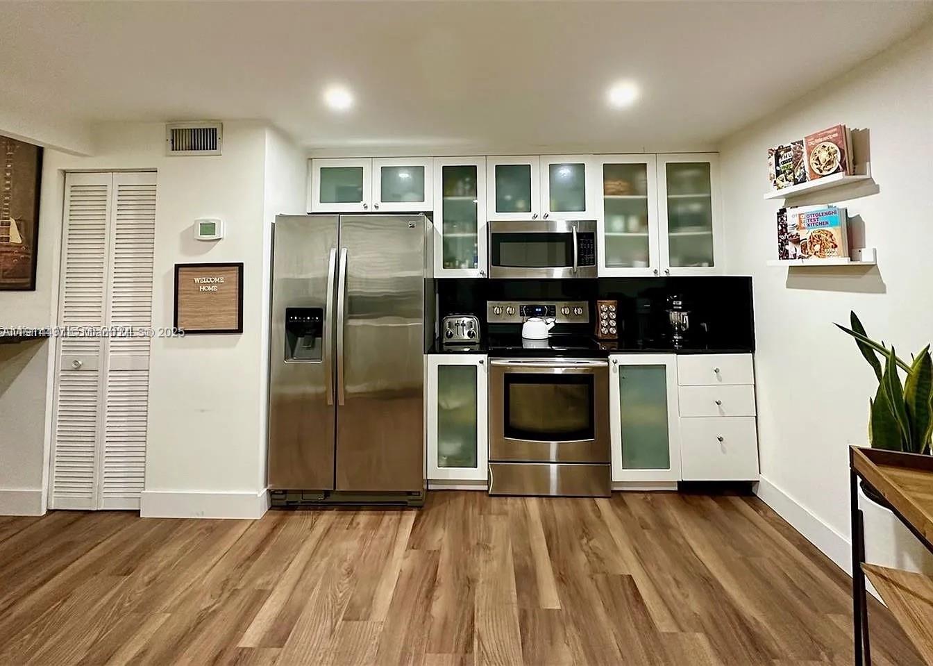 1881 Washington Avenue, Unit 4A Miami Beach, FL 33139 - Photo 2 of 15 a kitchen with stainless steel appliances granite countertop a refrigerator a stove and a sink
