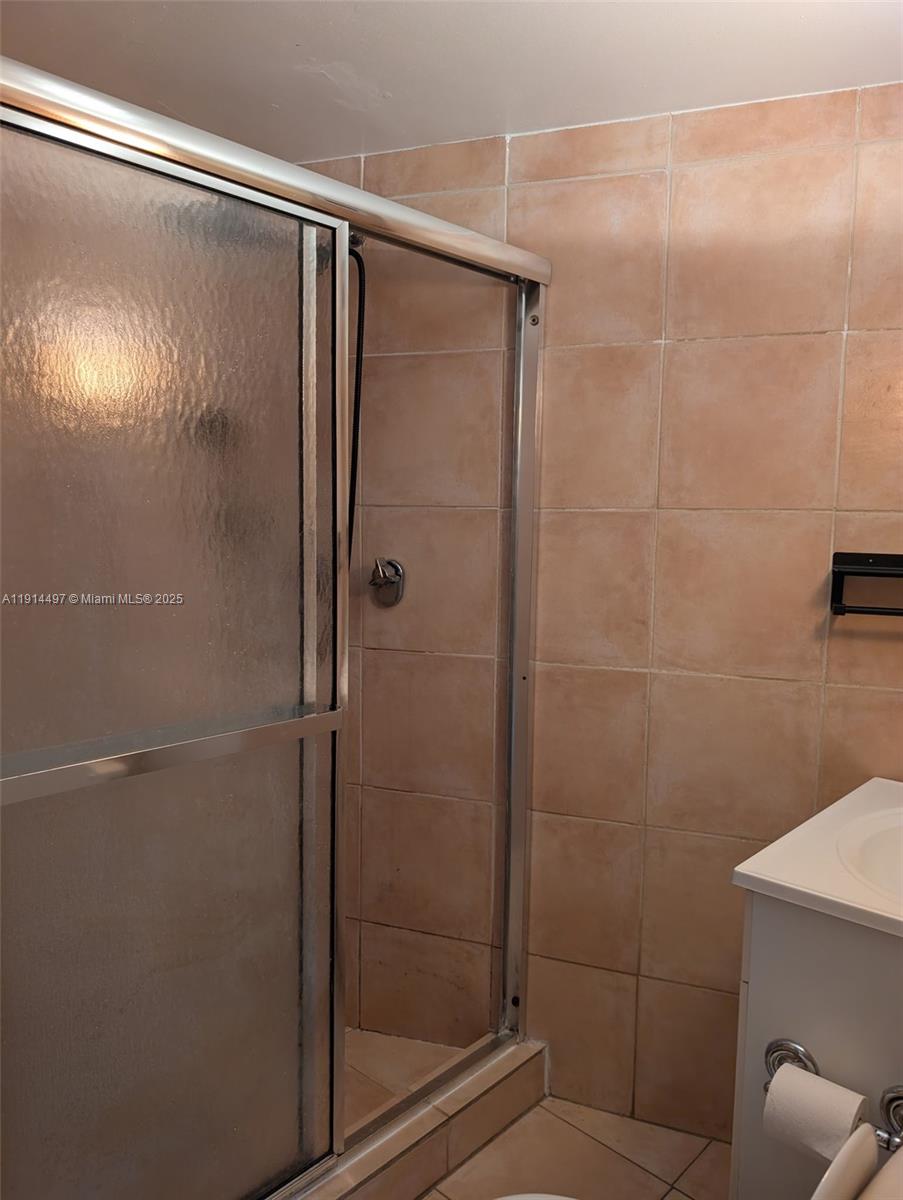 1881 Washington Avenue, Unit 4A Miami Beach, FL 33139 - Photo 10 of 15 a bathroom with a glass shower door