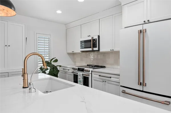 a kitchen with stainless steel appliances a white stove top oven and sink