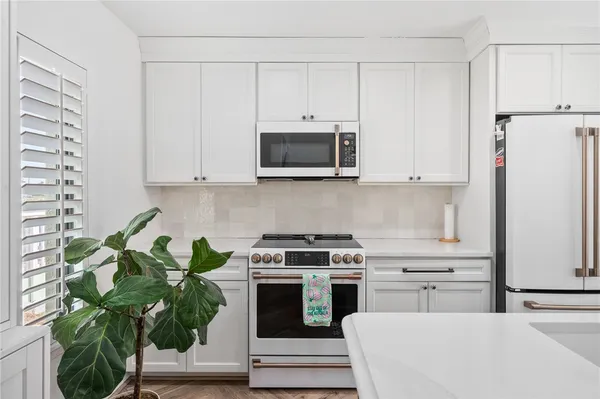 a kitchen with appliances a microwave and cabinets