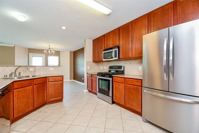 a large kitchen with stainless steel appliances granite countertop a refrigerator sink and cabinets