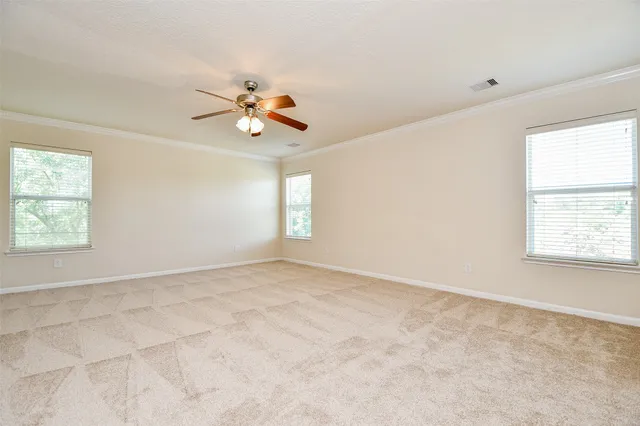 an empty room with windows and fan