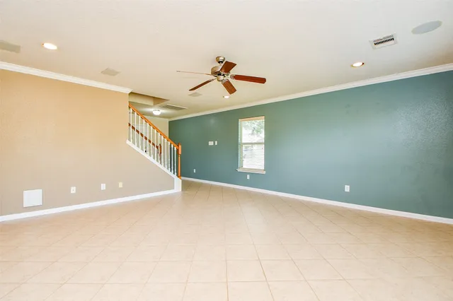 a view of a room with a ceiling fan and window