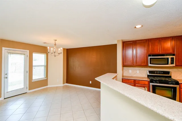a kitchen with stainless steel appliances a stove microwave and sink