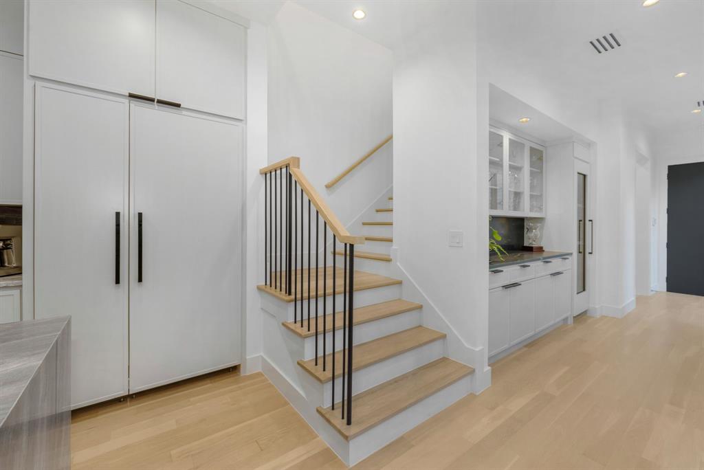 4214 Hawthorne Avenue Dallas, TX 75219 - Photo 16 of 39 a view of a hallway with staircase and door with wooden floor