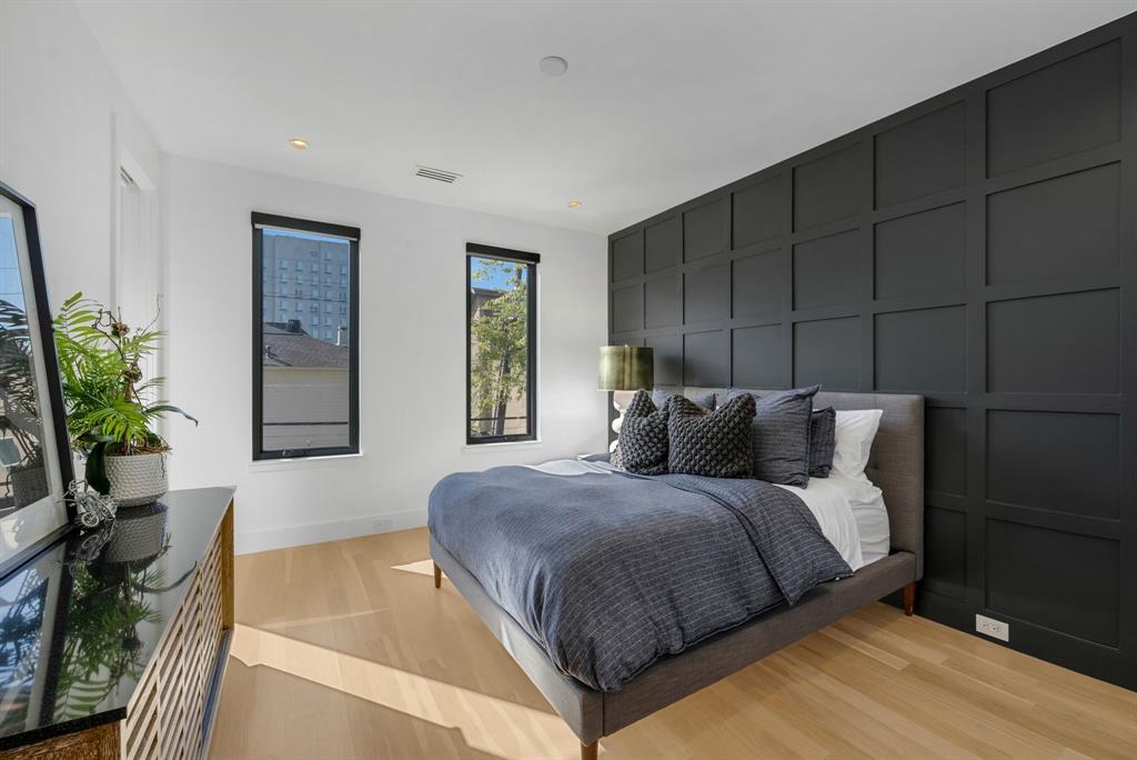 4214 Hawthorne Avenue Dallas, TX 75219 - Photo 17 of 39 a spacious bedroom with a bed and a potted plant