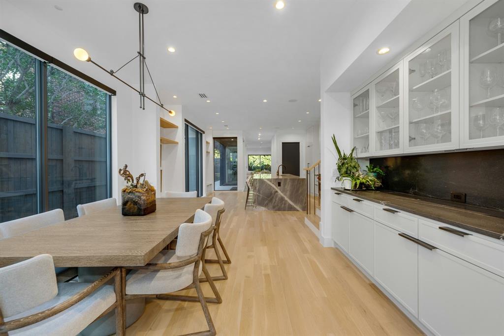 4214 Hawthorne Avenue Dallas, TX 75219 - Photo 6 of 39 a kitchen with stainless steel appliances kitchen island granite countertop a stove a refrigerator a sink a dining table and chairs with wooden floor