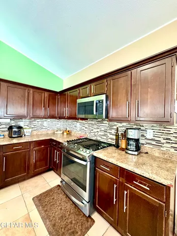 a kitchen with stainless steel appliances granite countertop a sink stove and cabinets