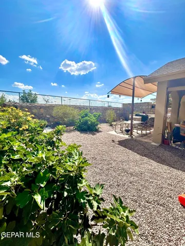 a view of a patio with table and chairs under an umbrella