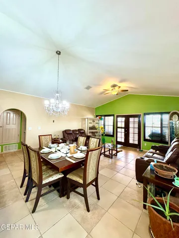 a dining room with furniture a chandelier and wooden floor