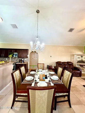 a living room with furniture a chandelier and a dining table