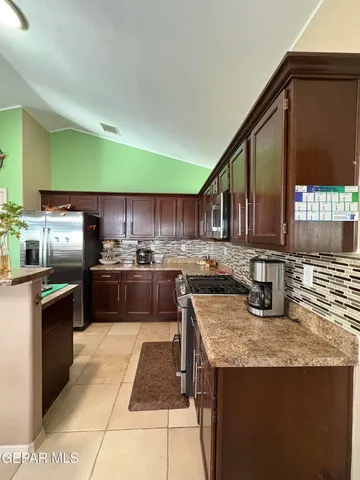 a kitchen with kitchen island granite countertop a sink counter top stainless steel appliances and cabinets