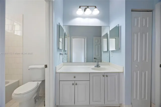 a bathroom with a toilet a sink a vanity and mirror