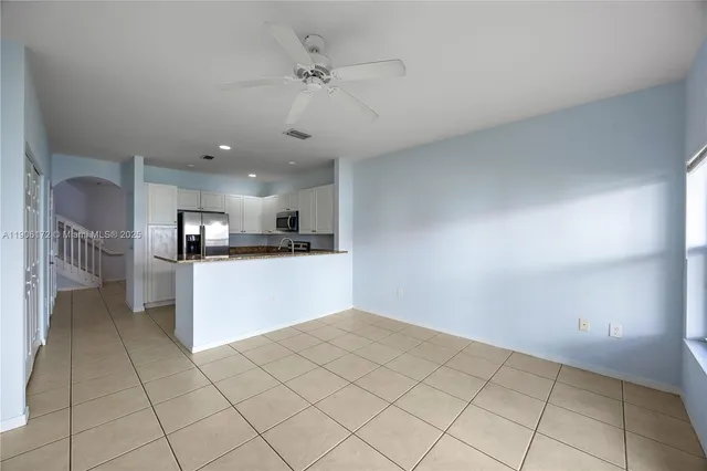 a view of kitchen with kitchen island microwave and refrigerator