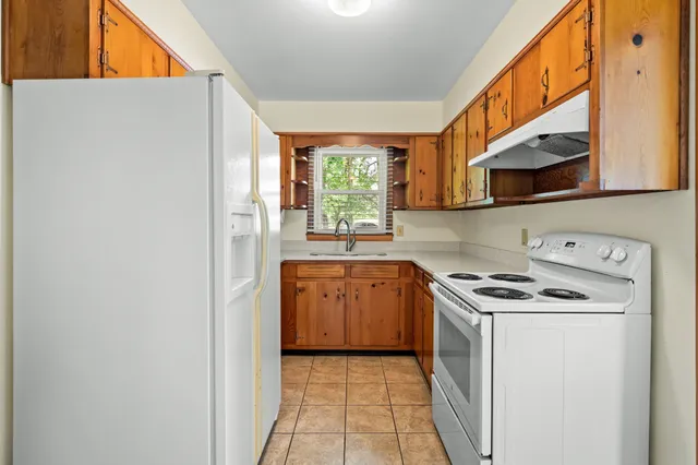 a kitchen with a stove a sink and a window
