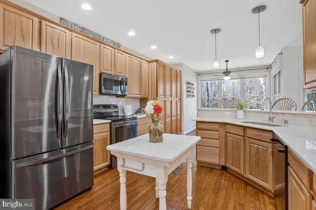 a kitchen with kitchen island a counter top space stainless steel appliances and cabinets