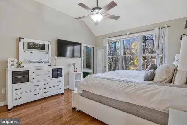 a bedroom with a bed a flat screen tv and a dresser