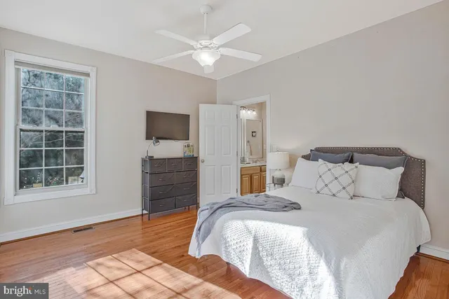 a bedroom with a bed and a flat tv screen on dresser