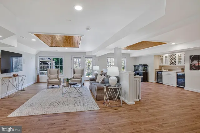a living room with furniture wooden floor and a large window