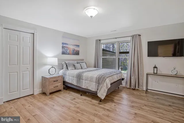 a bedroom with a bed and a flat tv screen on wall