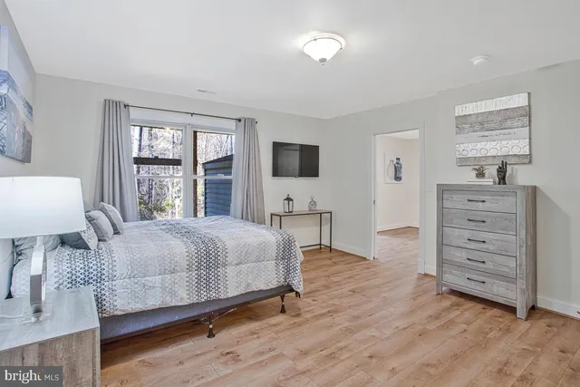 a bedroom with a bed and large windows