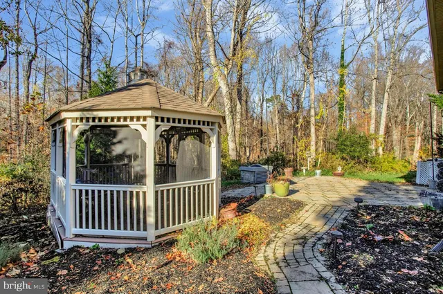 a view of a pathway that has wooden fence and a bench
