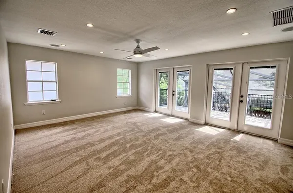 a view of an empty room with a window and a kitchen