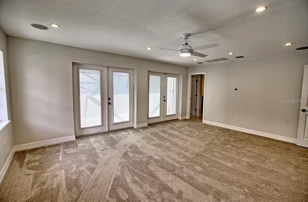 an empty room with fan and windows