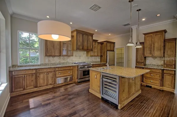 a kitchen with stainless steel appliances granite countertop a sink a stove and a refrigerator