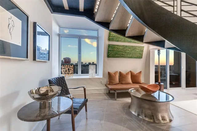 a living room with furniture and floor to ceiling windows