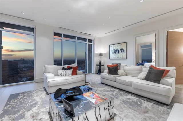 a spacious bedroom with a bed and a flat tv screen on dresser