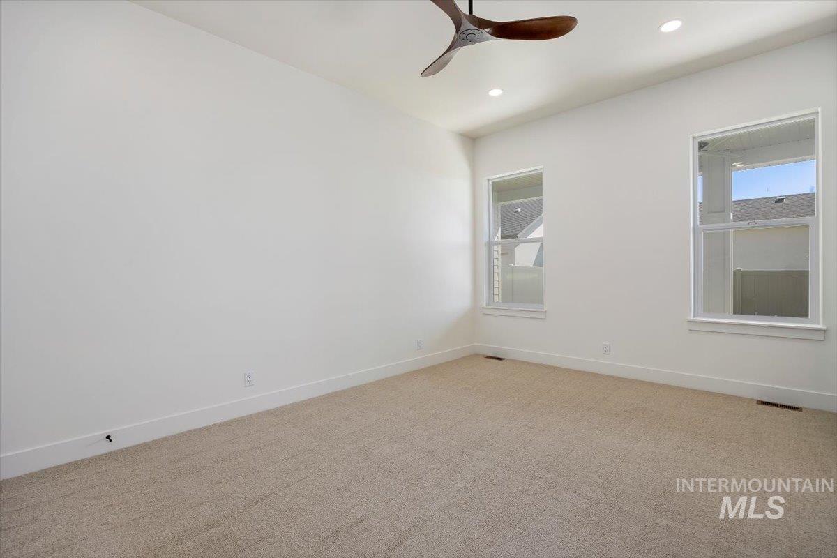 563 Moonstone Road Kimberly, ID 83341 - Photo 22 of 48 Vaulted ceiling with recessed lighting and a ceiling fan, two windows with white trim, and neutral-toned carpet