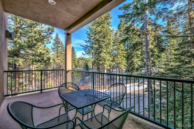 a view of a balcony with chairs and wooden fence