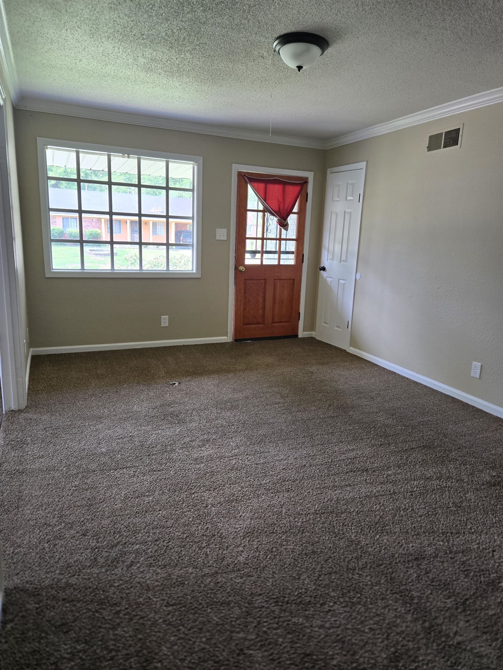 4207 Kenosha Road Memphis, TN 38118 - Photo 12 of 24 Carpeted foyer featuring crown molding, a textured ceiling, and baseboards