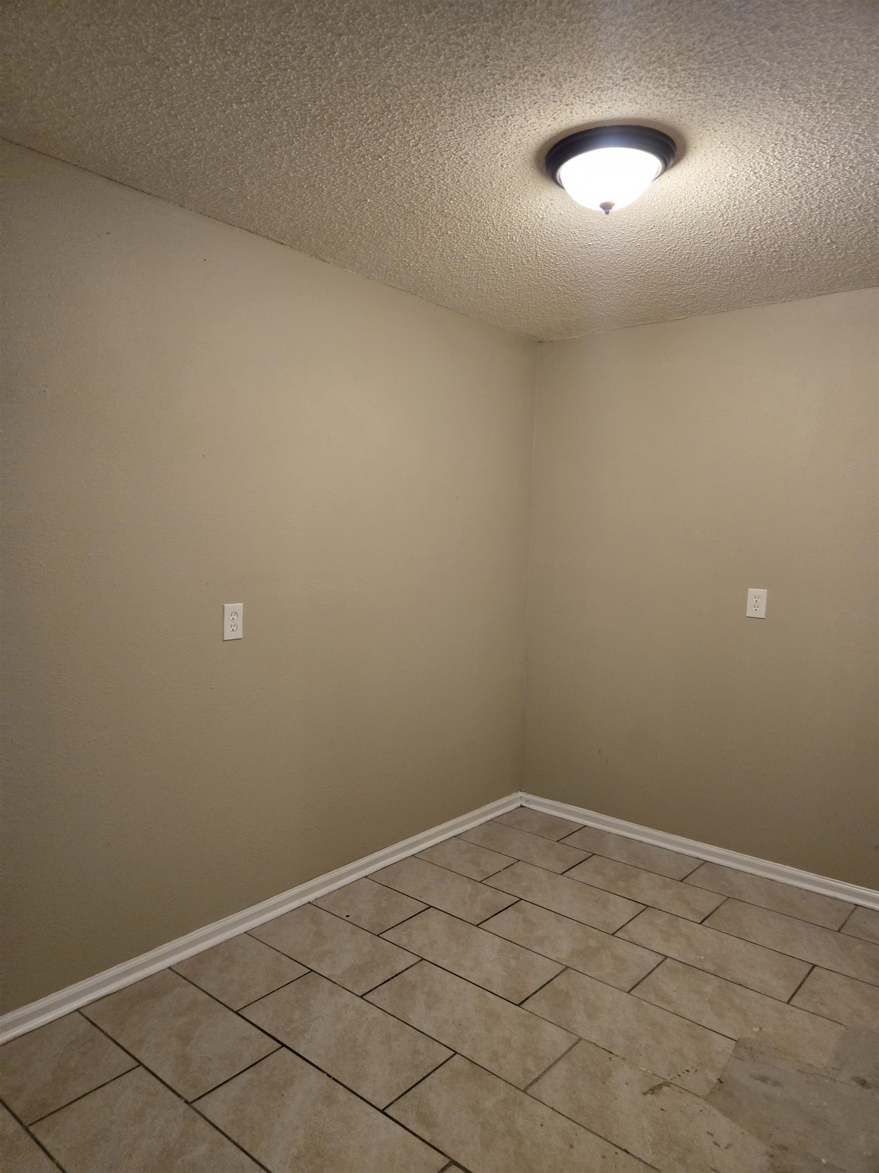 4207 Kenosha Road Memphis, TN 38118 - Photo 15 of 24 Spare room featuring a textured ceiling, light tile patterned floors, and baseboards