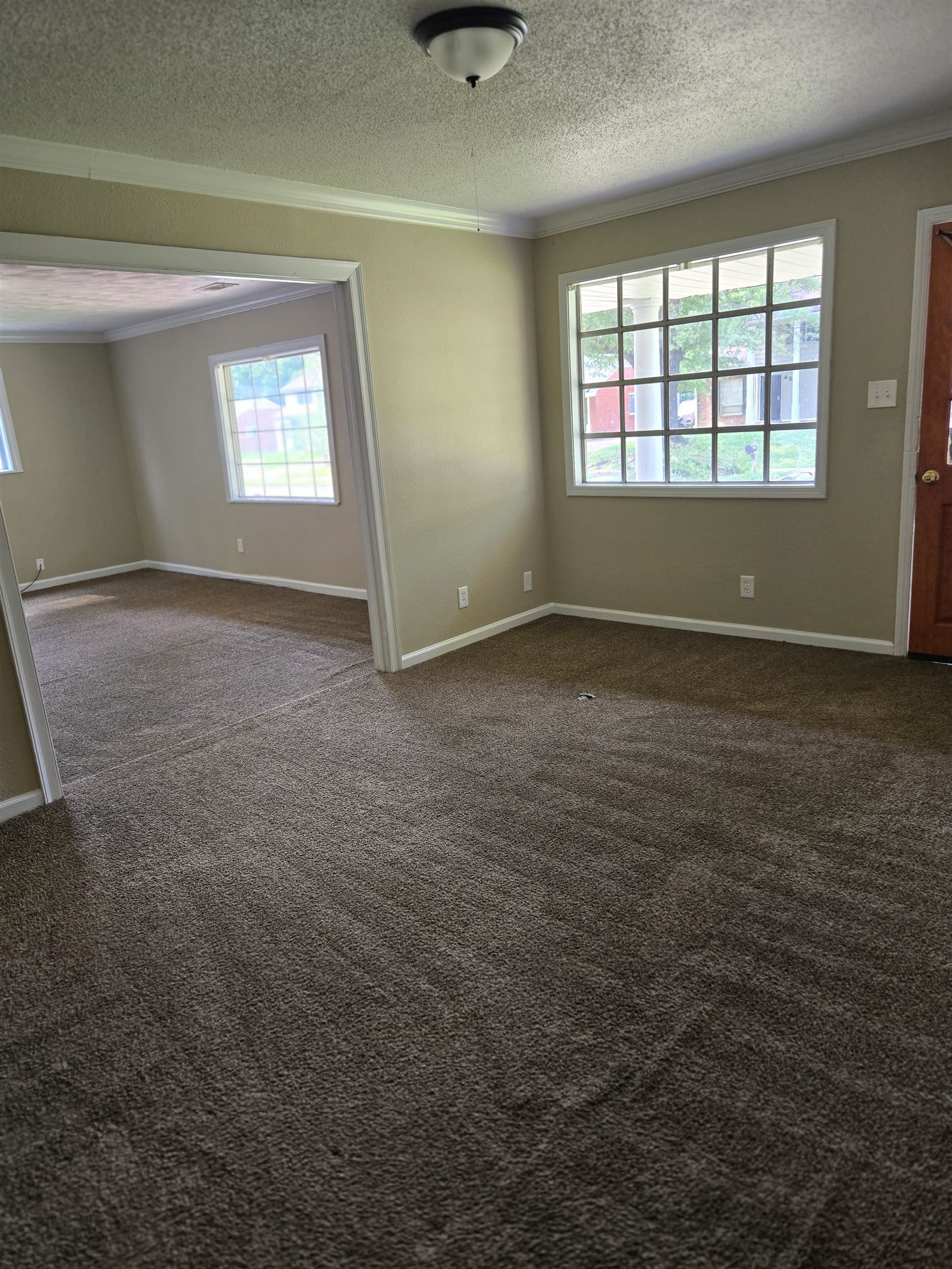 4207 Kenosha Road Memphis, TN 38118 - Photo 3 of 24 Carpeted spare room with ornamental molding, a textured ceiling, and baseboards
