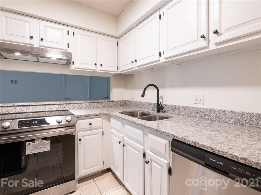 a kitchen with white cabinets and appliances
