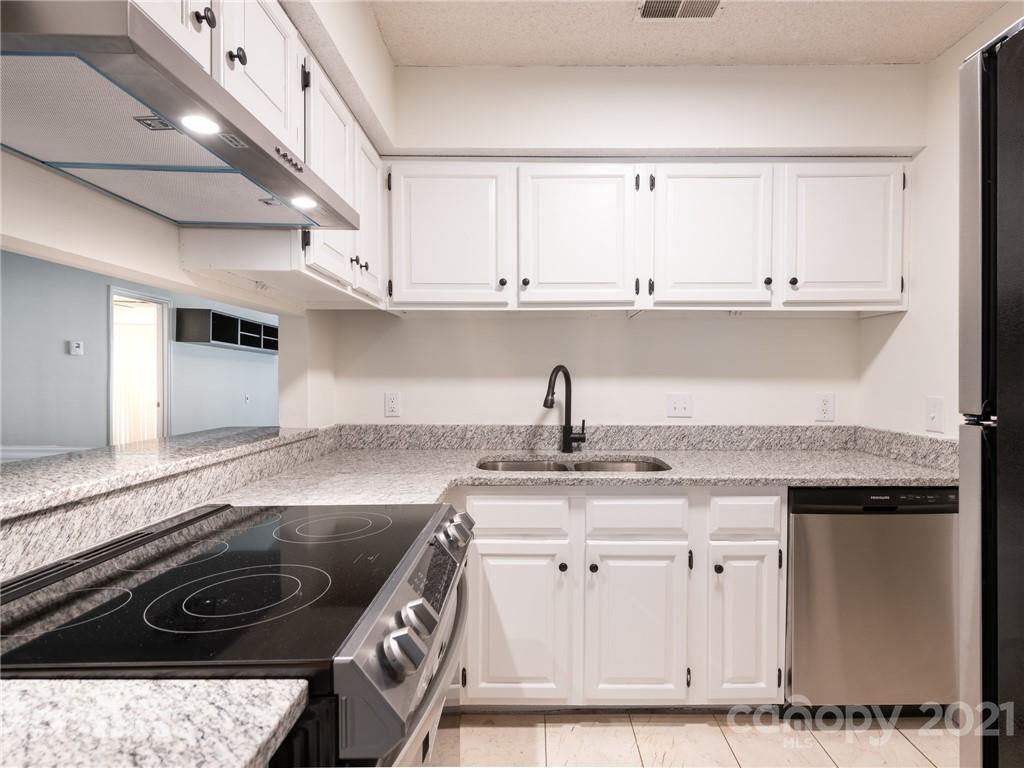 1604 Sharon Road West, Unit 24 Charlotte, NC 28210 - Photo 11 of 25 a kitchen with granite countertop a sink a stove and cabinets