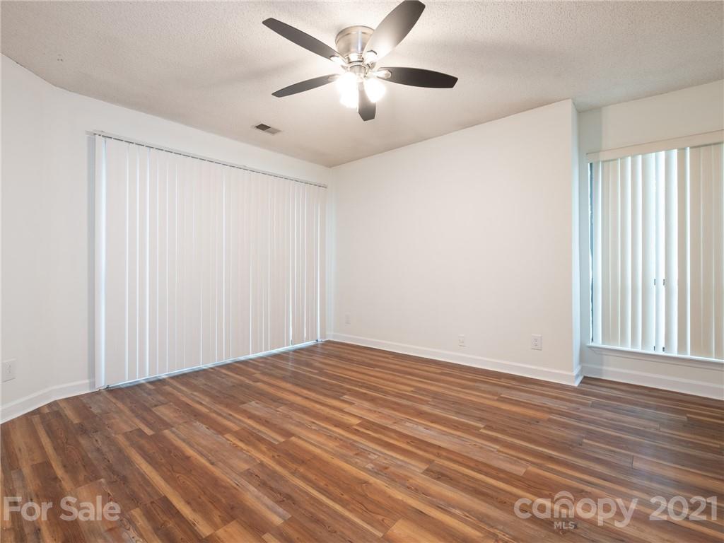 1604 Sharon Road West, Unit 24 Charlotte, NC 28210 - Photo 18 of 25 a view of a room with wooden floor and a ceiling fan