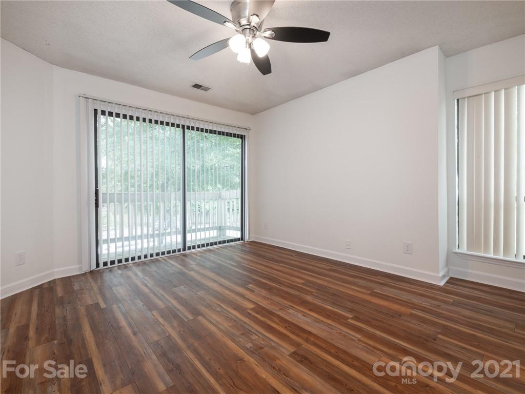 1604 Sharon Road West, Unit 24 Charlotte, NC 28210 - Photo 20 of 25 a view of an empty room with wooden floor and a window
