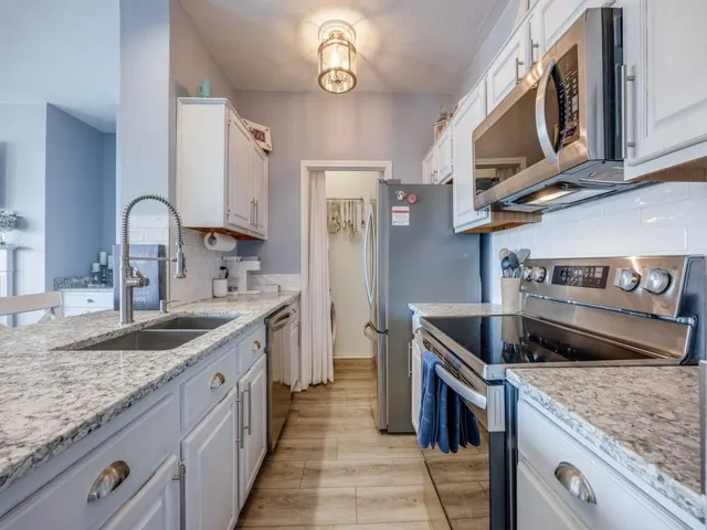 a kitchen with stainless steel appliances granite countertop a sink and cabinets