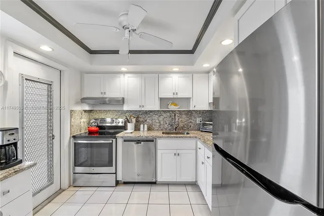 a kitchen with stainless steel appliances granite countertop a sink stove refrigerator and cabinets