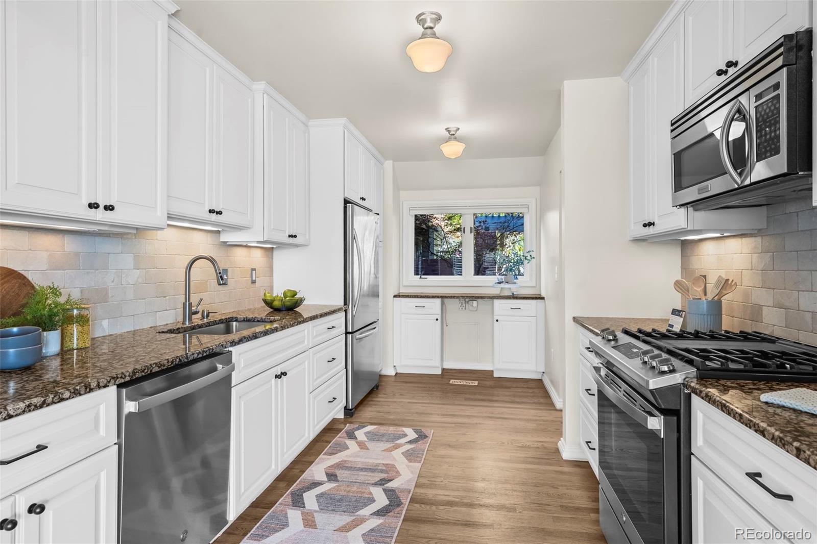 7264 Siena Way, Unit C Boulder, CO 80301 - Photo 11 of 48 a kitchen with stainless steel appliances granite countertop a stove sink and cabinets