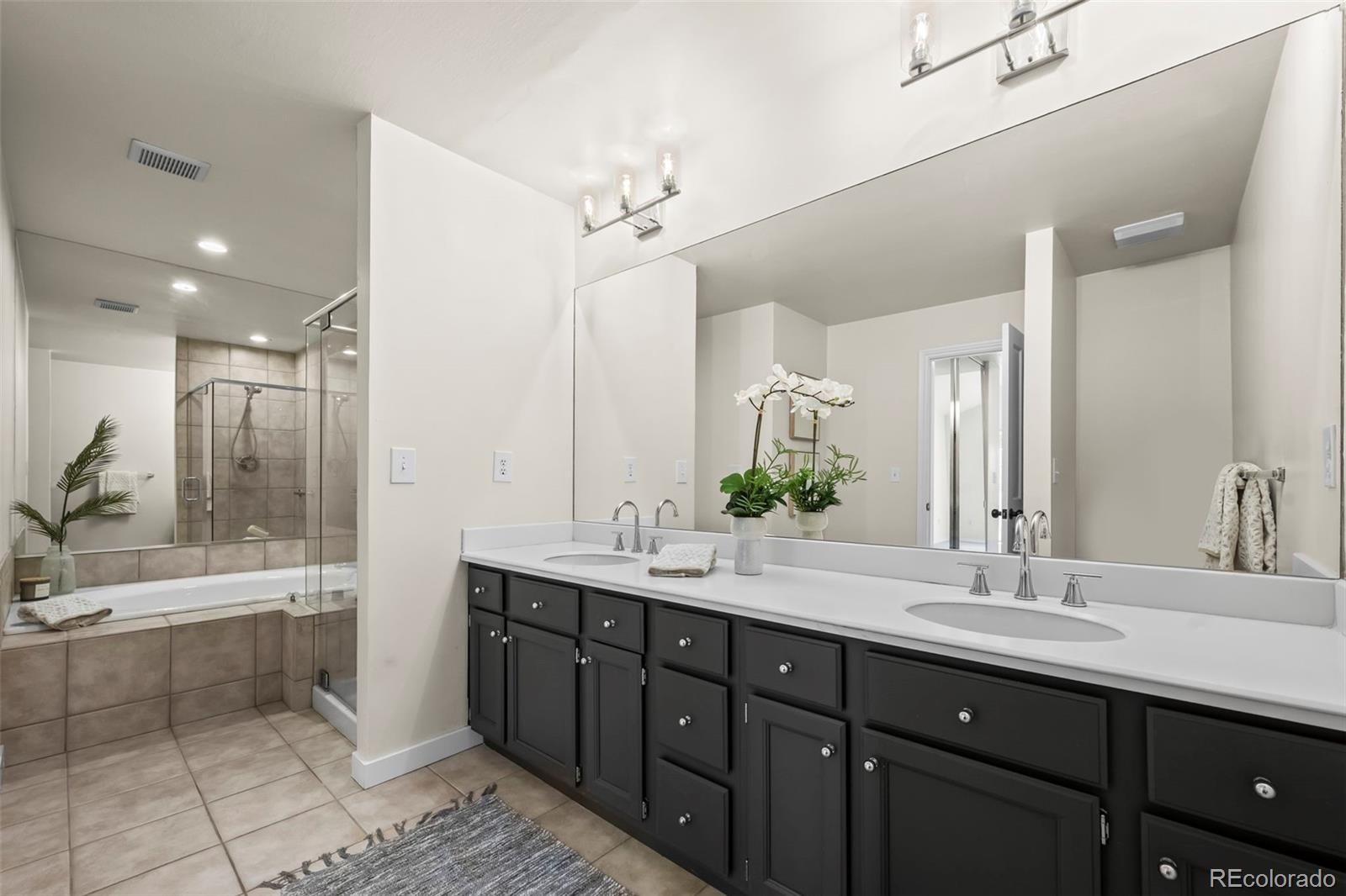 7264 Siena Way, Unit C Boulder, CO 80301 - Photo 31 of 48 a bathroom with a double vanity sink a large mirror and a bathtub