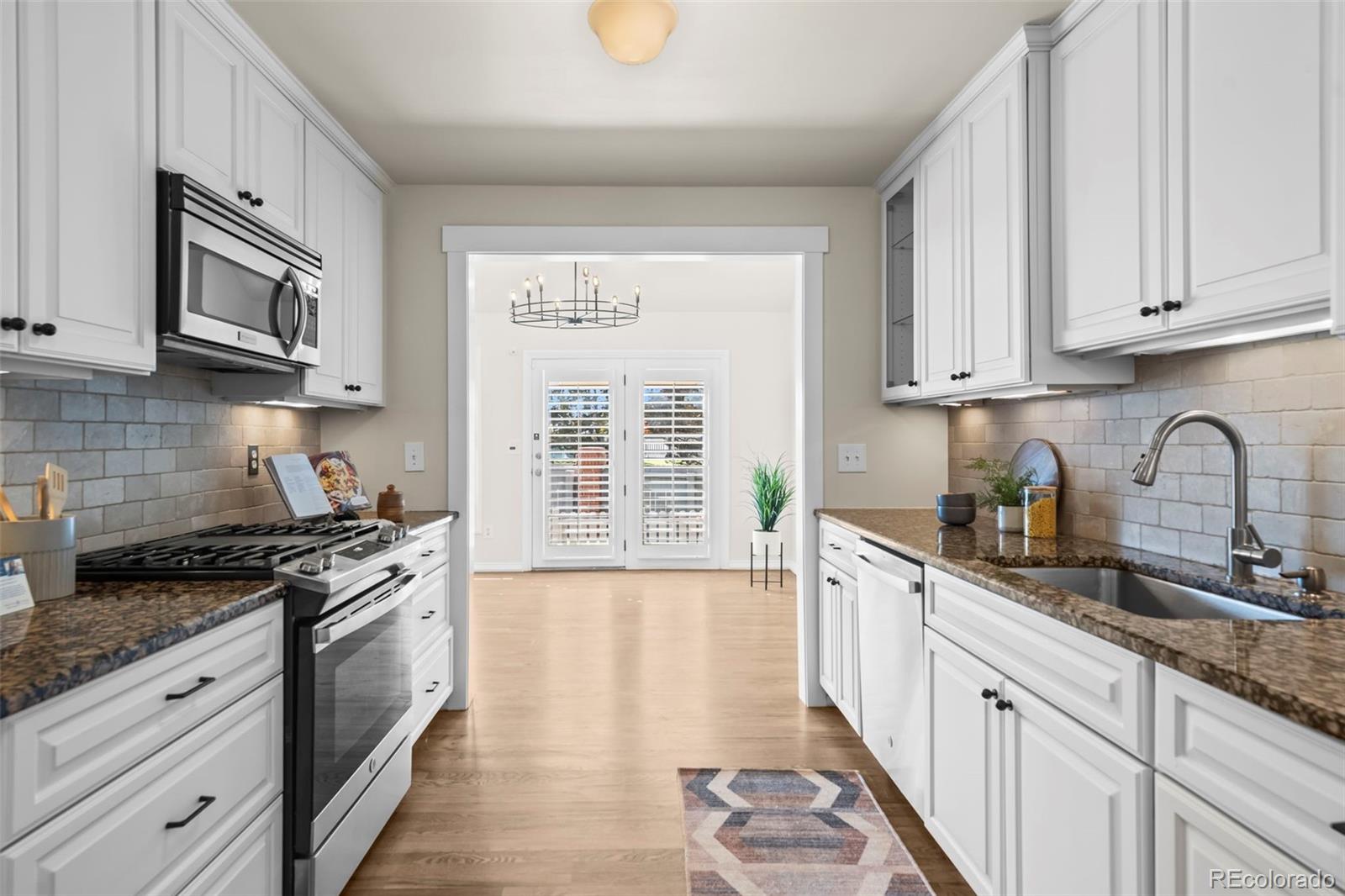 7264 Siena Way, Unit C Boulder, CO 80301 - Photo 8 of 48 a kitchen with stainless steel appliances granite countertop white cabinets a sink a stove a window and dishwasher