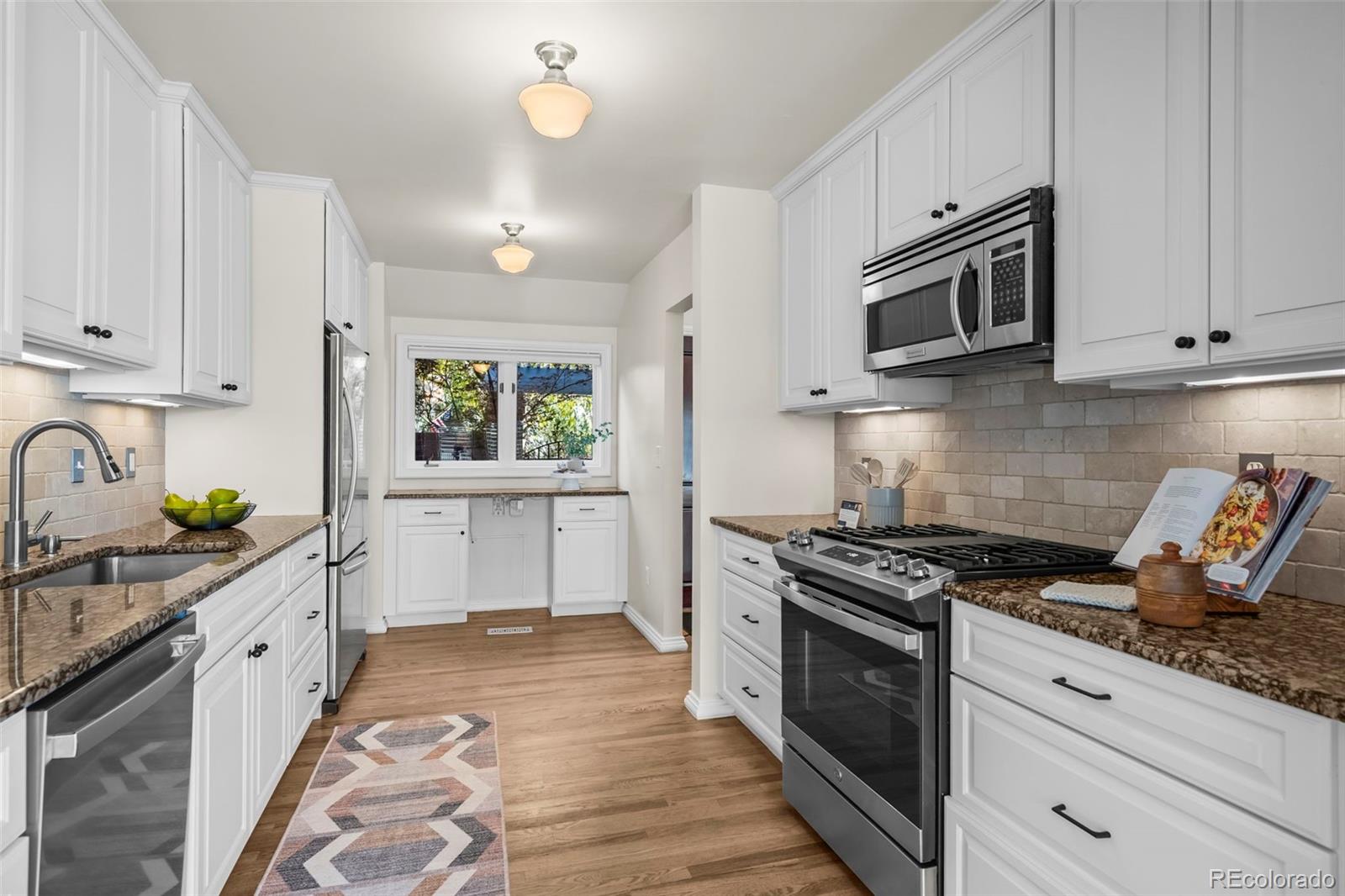 7264 Siena Way, Unit C Boulder, CO 80301 - Photo 10 of 48 a kitchen with stainless steel appliances granite countertop a stove a sink dishwasher and a microwave oven with white cabinets