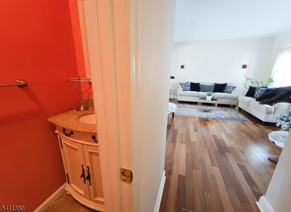 a view of a living room with a sink and wooden floor