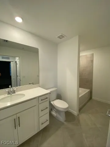 a bathroom with a sink a toilet a mirror and shower